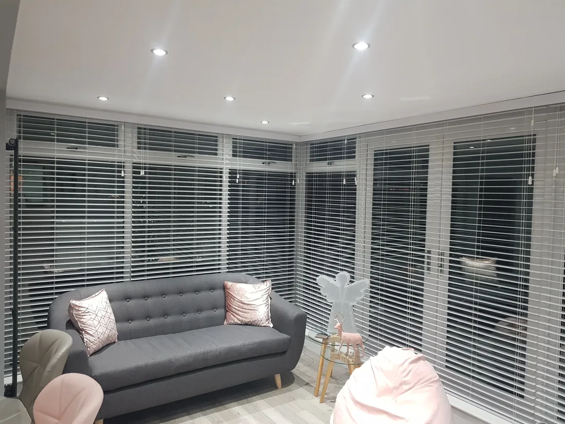 White faux wood venetian blinds in a garden room